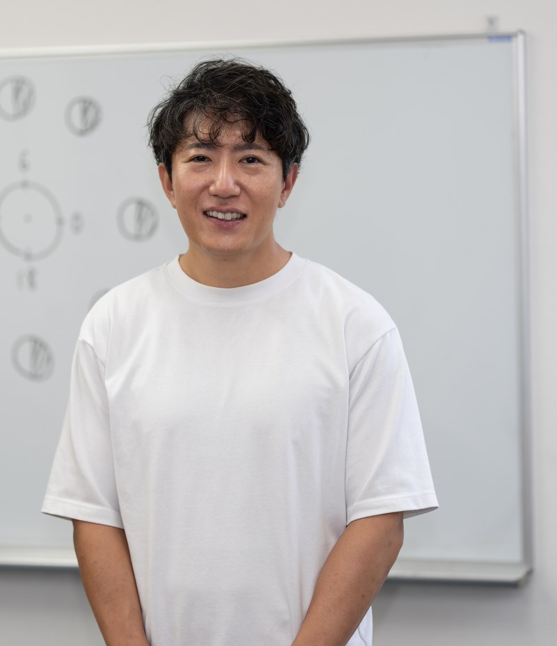 ホワイトボードの前で撮影した講師のポートレート