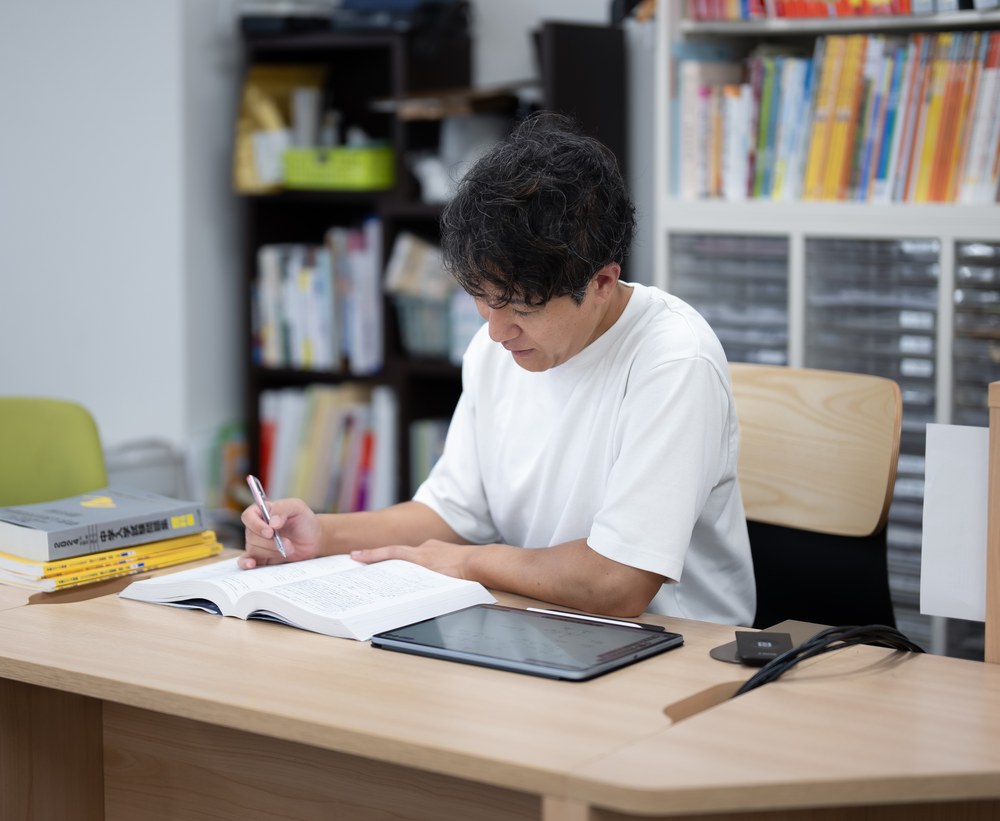 教材を開き、書き込みながら研究する様子